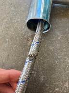 A damaged flexible hose with a visible tear.